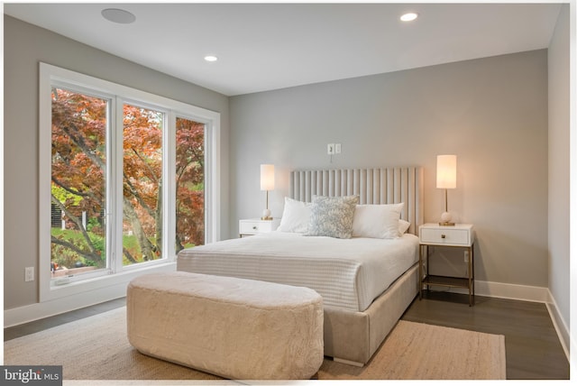 bedroom with hardwood / wood-style flooring and multiple windows