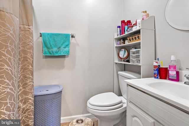 bathroom with walk in shower, vanity, and toilet