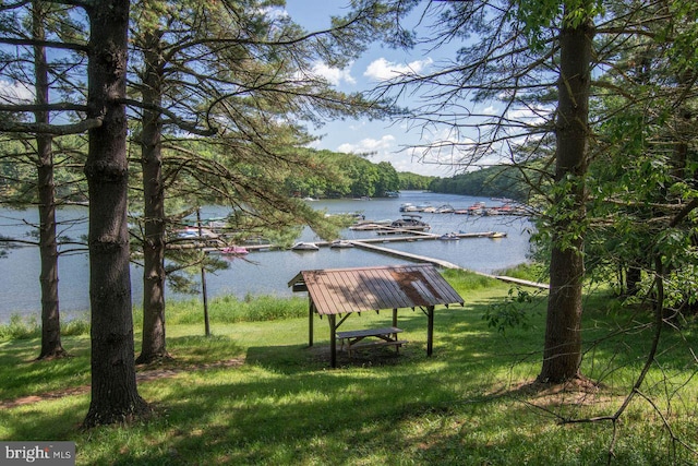 view of community with a lawn and a water view