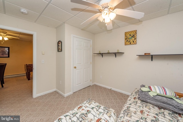 bedroom featuring ceiling fan, a drop ceiling, light colored carpet, and a baseboard heating unit