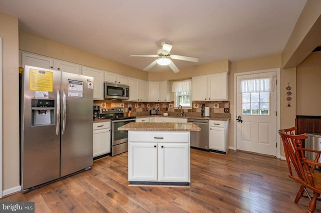 kitchen featuring white cabinets, backsplash, stainless steel appliances, and dark wood-type flooring