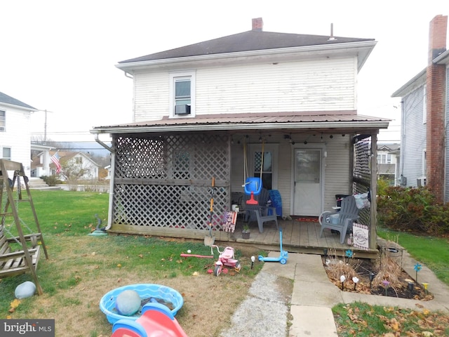 rear view of property featuring a lawn