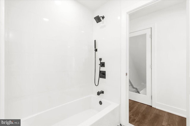 bathroom featuring wood-type flooring and tiled shower / bath