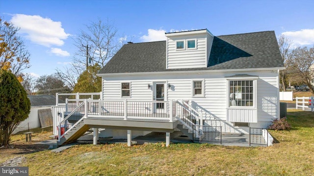 rear view of property with a deck and a yard