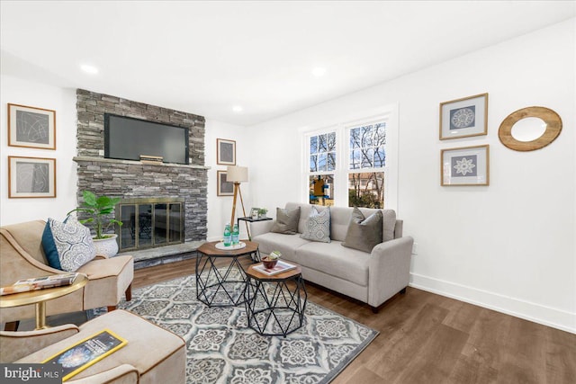 living room featuring a stone fireplace and hardwood / wood-style flooring