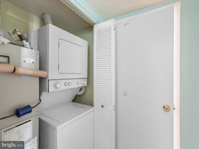 laundry area featuring a textured ceiling and stacked washer / dryer