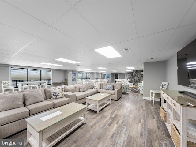 living room featuring hardwood / wood-style floors and a drop ceiling