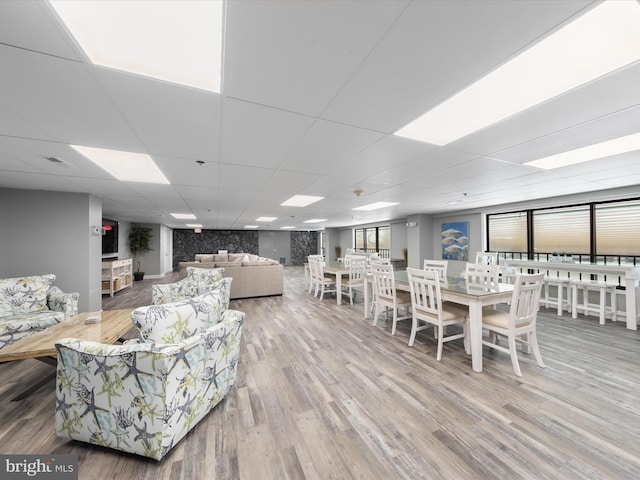 living room featuring hardwood / wood-style floors and a drop ceiling