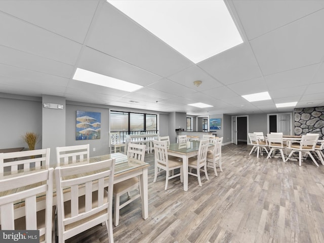 dining room with hardwood / wood-style floors and a drop ceiling