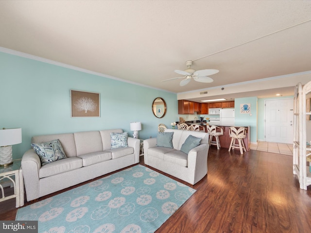 living room with dark hardwood / wood-style floors, ceiling fan, and crown molding