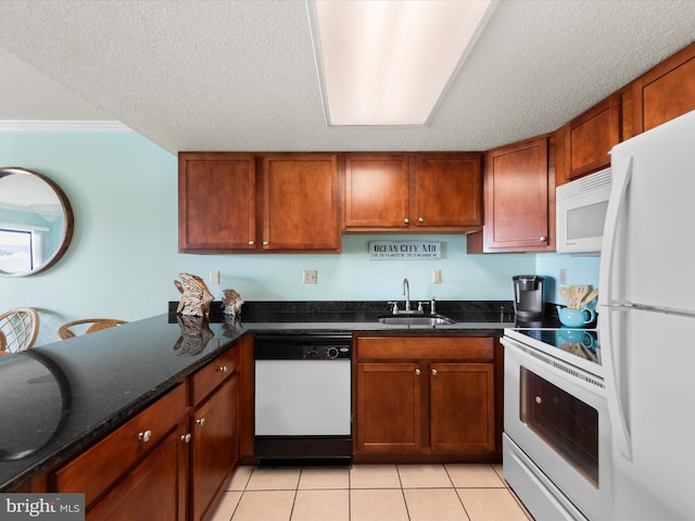 kitchen with white appliances, sink, dark stone countertops, light tile patterned floors, and a textured ceiling