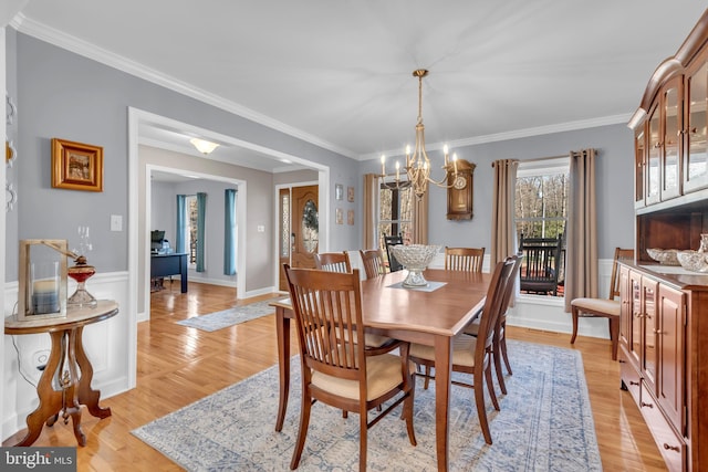 dining space with a chandelier, light hardwood / wood-style floors, and ornamental molding