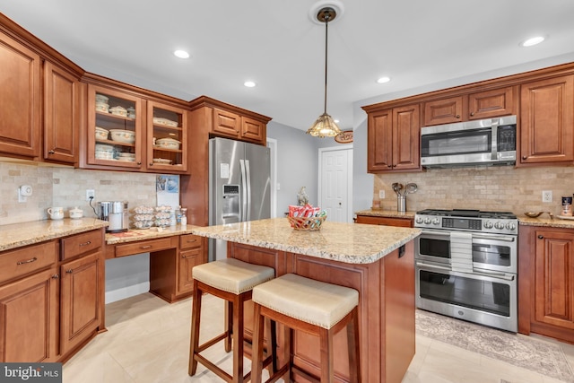 kitchen featuring a kitchen bar, pendant lighting, backsplash, and stainless steel appliances