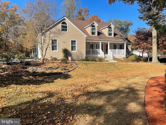 cape cod house featuring covered porch and a front yard