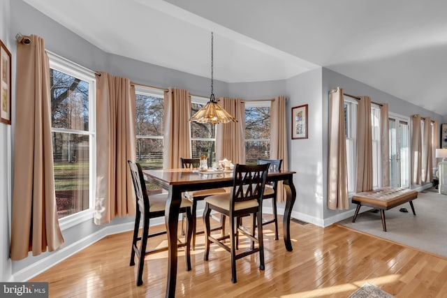 dining area with a wealth of natural light, light wood-type flooring, and a notable chandelier