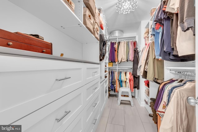 spacious closet featuring an inviting chandelier