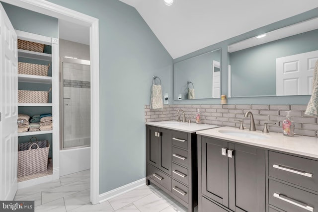 bathroom featuring backsplash, vanity, enclosed tub / shower combo, and lofted ceiling