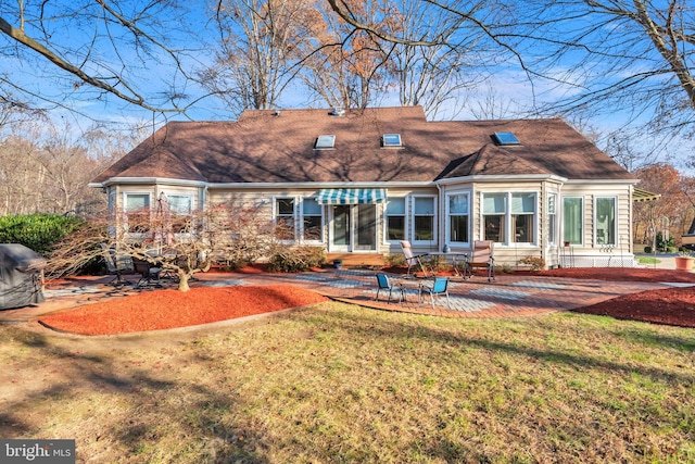 back of house featuring a lawn and a patio