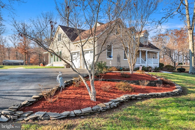 view of side of home featuring a porch and a garage