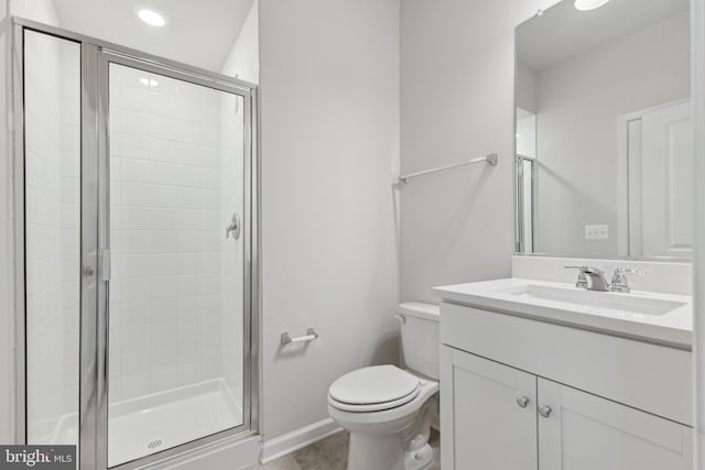 bathroom with tile patterned floors, vanity, a shower with shower door, and toilet