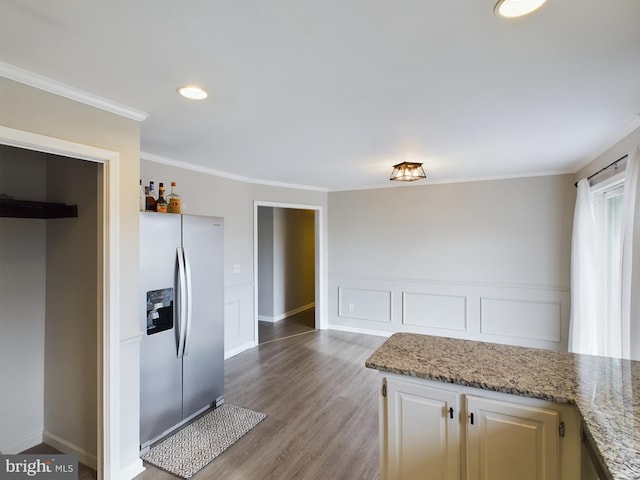 kitchen featuring light stone countertops, stainless steel fridge with ice dispenser, hardwood / wood-style flooring, and crown molding