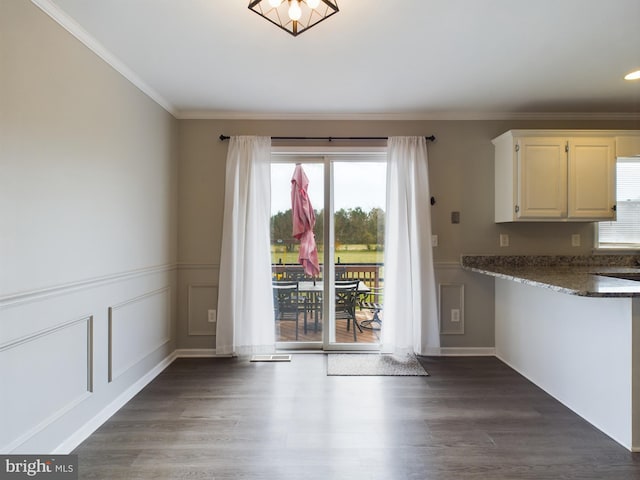 unfurnished dining area featuring dark hardwood / wood-style floors and ornamental molding