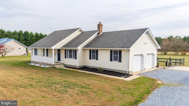 view of front facade featuring a garage, covered porch, and a front yard