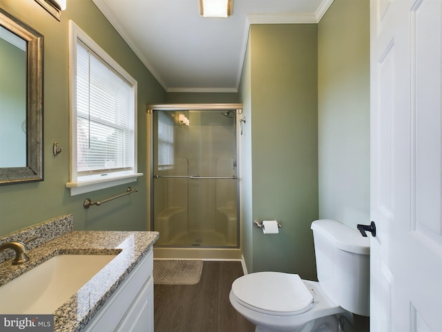 bathroom featuring vanity, crown molding, hardwood / wood-style floors, toilet, and a shower with shower door