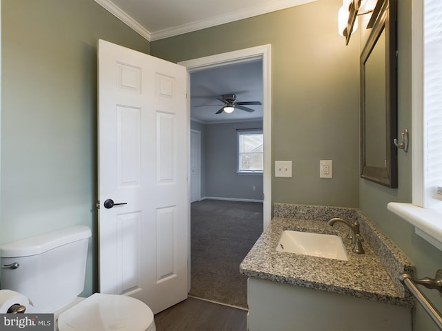 bathroom featuring hardwood / wood-style floors, vanity, ceiling fan, toilet, and ornamental molding