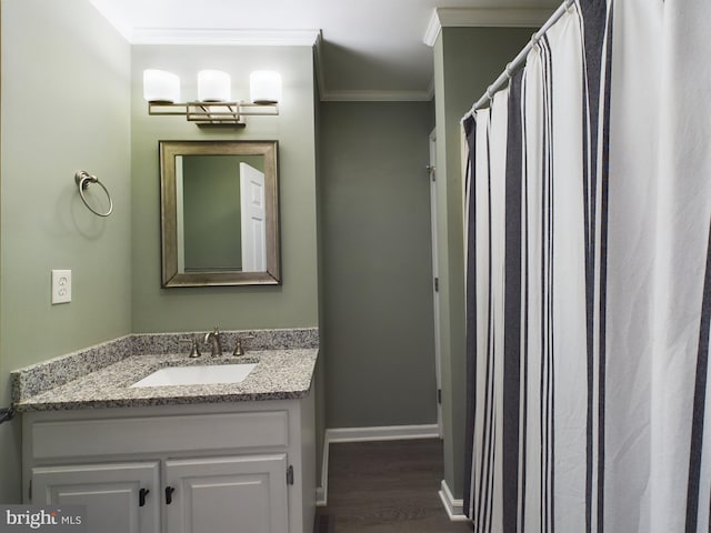 bathroom featuring hardwood / wood-style floors, vanity, and crown molding