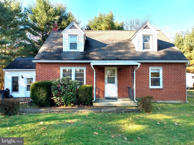 cape cod house featuring a front lawn