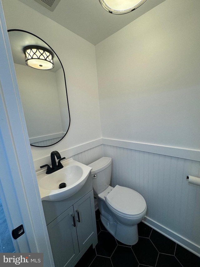 bathroom featuring tile patterned flooring, vanity, and toilet