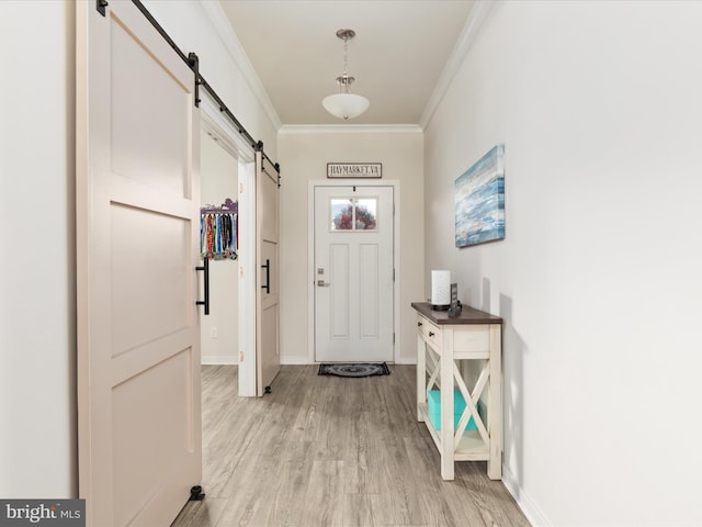 doorway to outside featuring light wood-type flooring, a barn door, and crown molding