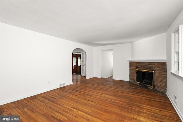 unfurnished living room featuring dark wood-type flooring and a fireplace