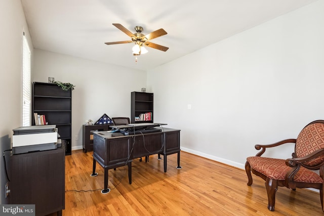 home office with light hardwood / wood-style floors and ceiling fan