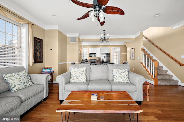 living room featuring crown molding, wood-type flooring, and ceiling fan with notable chandelier