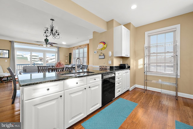 kitchen with sink, kitchen peninsula, black dishwasher, and a wealth of natural light