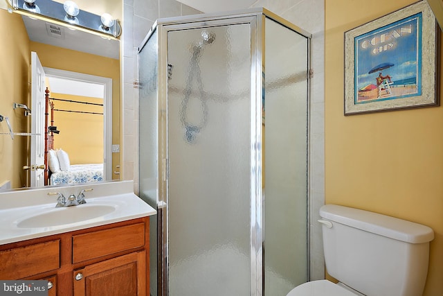 bathroom with an enclosed shower, vanity, and toilet