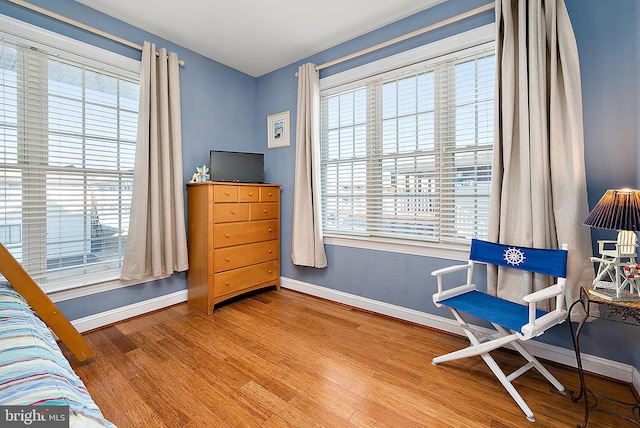 living area with hardwood / wood-style flooring and a healthy amount of sunlight