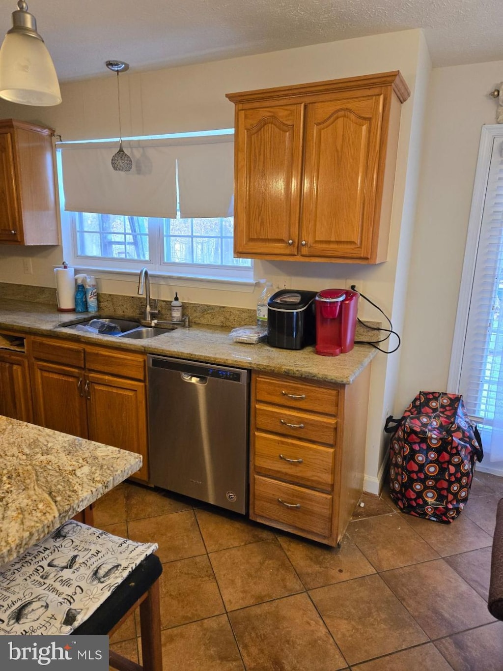 kitchen with tile patterned floors, sink, decorative light fixtures, a textured ceiling, and dishwasher