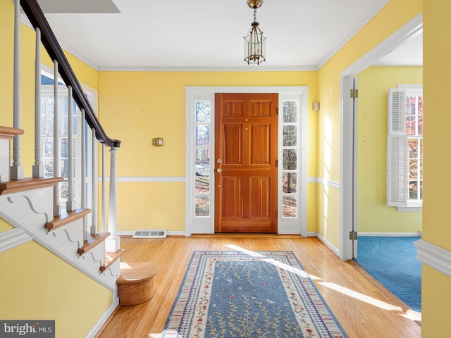 foyer featuring light hardwood / wood-style flooring and crown molding