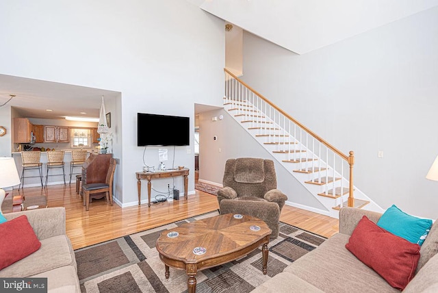 living room with a high ceiling and light hardwood / wood-style floors