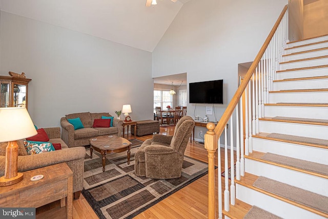 living room with hardwood / wood-style floors and high vaulted ceiling