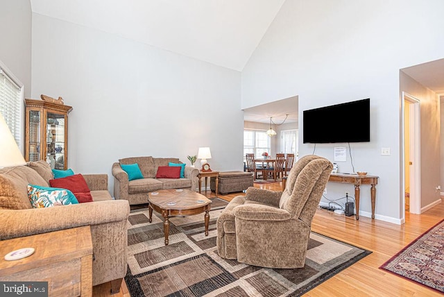 living room featuring high vaulted ceiling and wood-type flooring