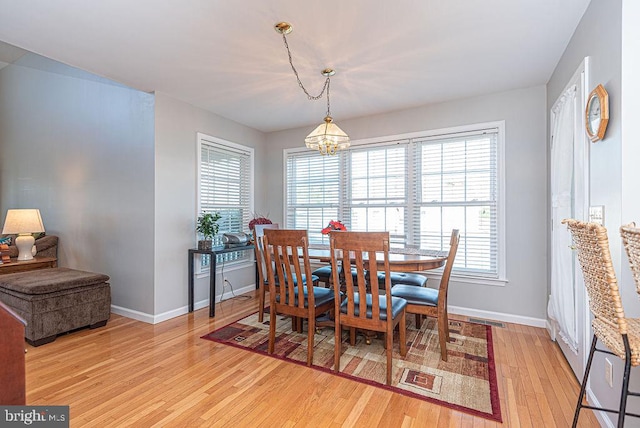 dining room featuring an inviting chandelier, a healthy amount of sunlight, and light wood-type flooring