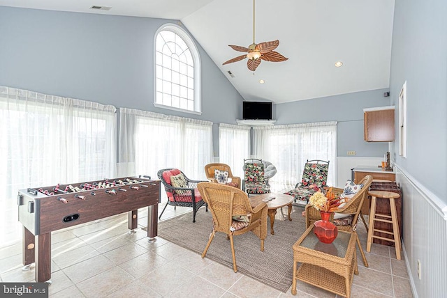 game room with ceiling fan, light tile patterned floors, and high vaulted ceiling