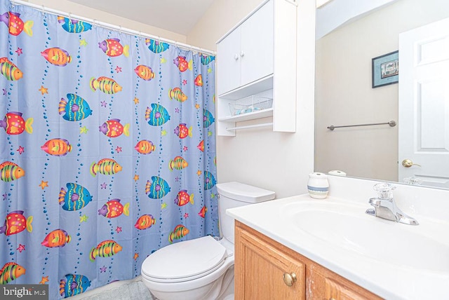 bathroom with vanity, curtained shower, and toilet