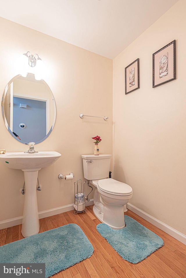 bathroom with hardwood / wood-style floors and toilet