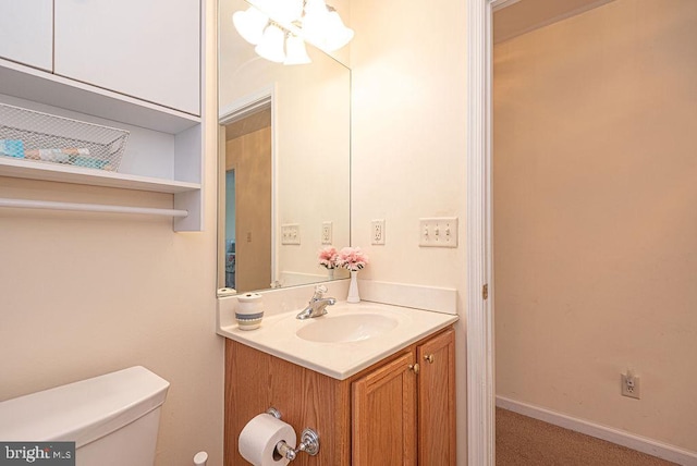 bathroom with vanity, a notable chandelier, and toilet