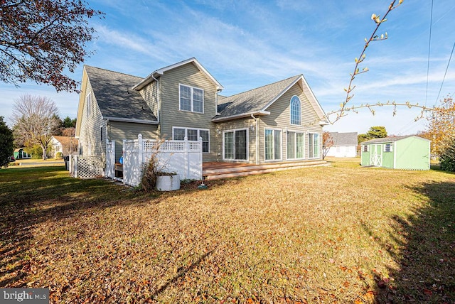 back of property with a yard, a deck, and a storage unit